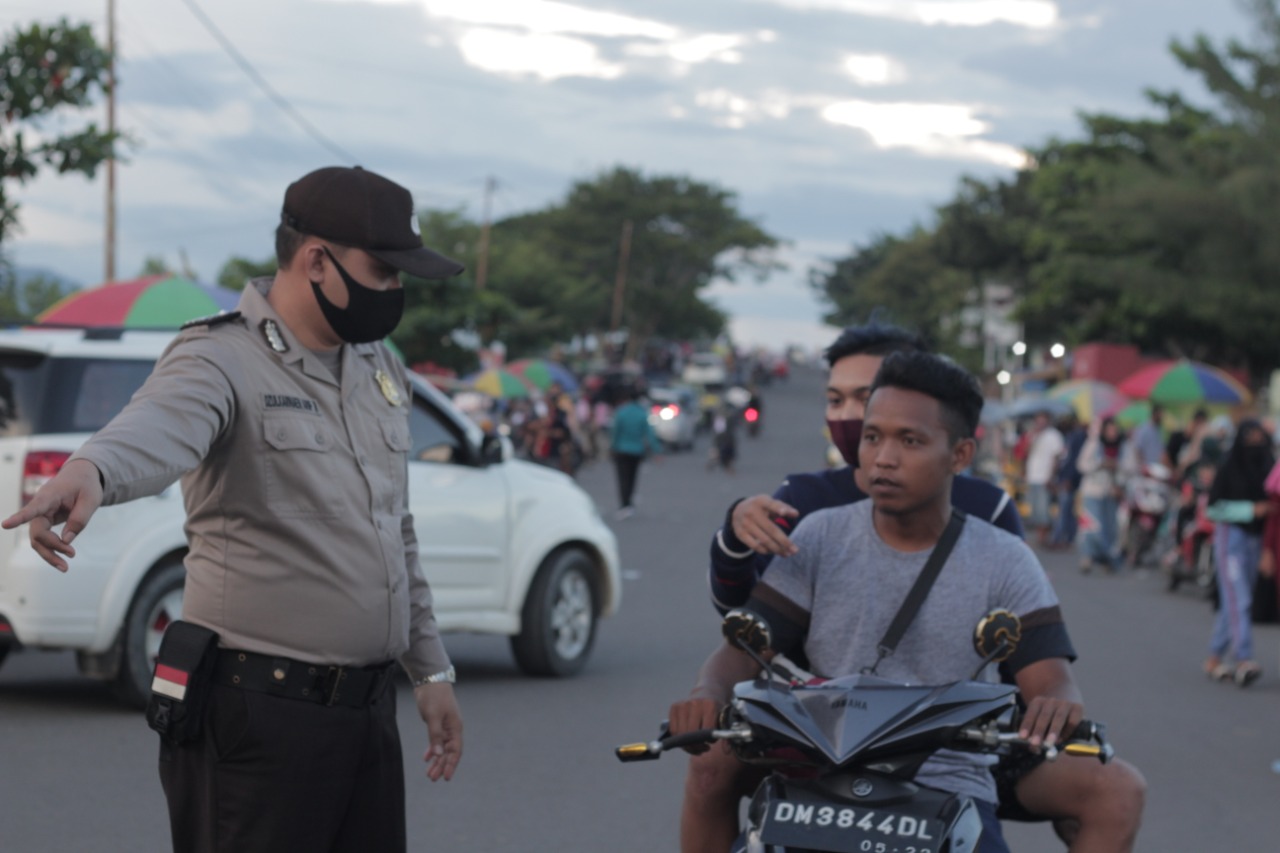 pihak kepolisian melakukan razia masker pada pengunjung di kawasan pantai pohon cinta. Foto: Zulkifli Mangkau