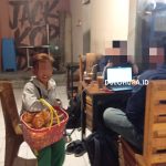 Seorang anak saat menjajakan jualan pada pengunjung warkop di malam hari/Yunita Humola