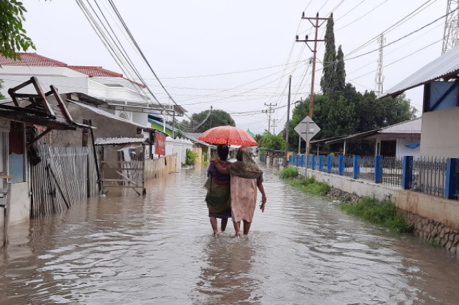 Dua warga berada di tengah banjir/Wawan Akuba
