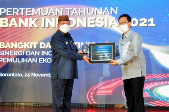 Wagub Gorontalo H. Idris Rahim (kiri) menerima penghargaan dari Kepala Perwakilan BI Gorontalo atas pencapaian jumlah merchat QRIS di wilayah Gorontalo yang melebihi target nasional pada Pertemuan Tahunan BI 2021, Rabu (24/11/2021).