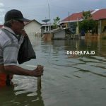 Seorang pria baru baya di Desa Buhu saat berada di genangan banjir/Melki Gani