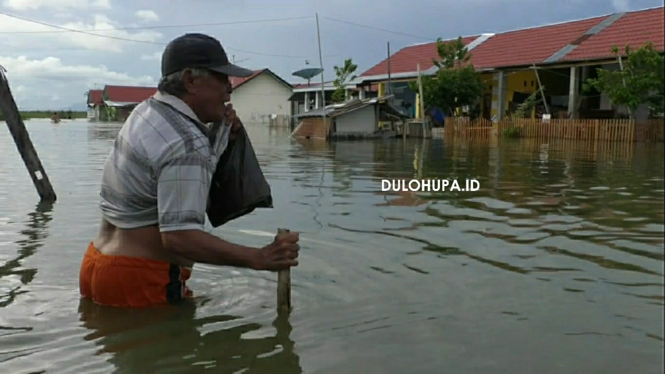 Seorang pria baru baya di Desa Buhu saat berada di genangan banjir/Melki Gani
